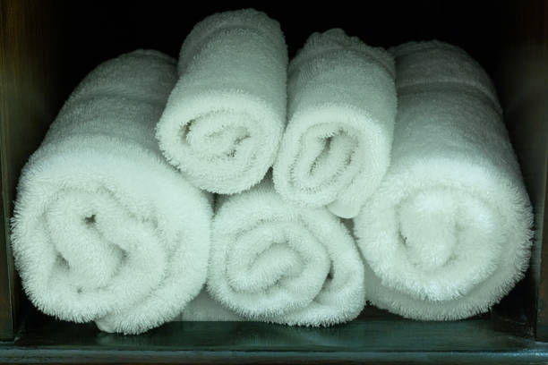 istock Stack of White Towel in Wooden Shelf on the Table 1306081792