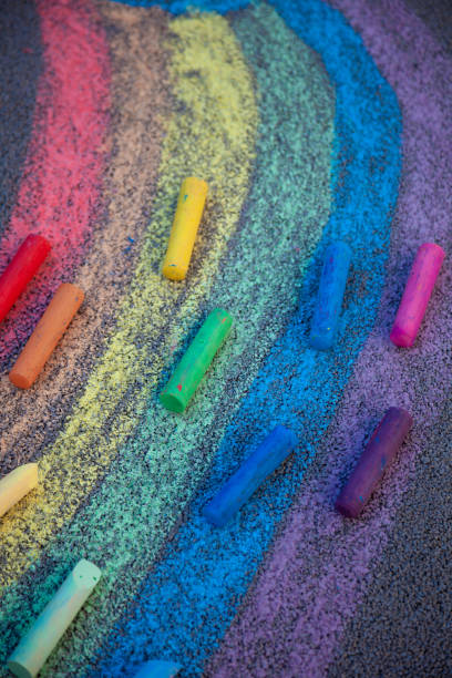 istock Chalk drawing. A rainbow painted on the asphalt with multicolored large crayons 1306082143