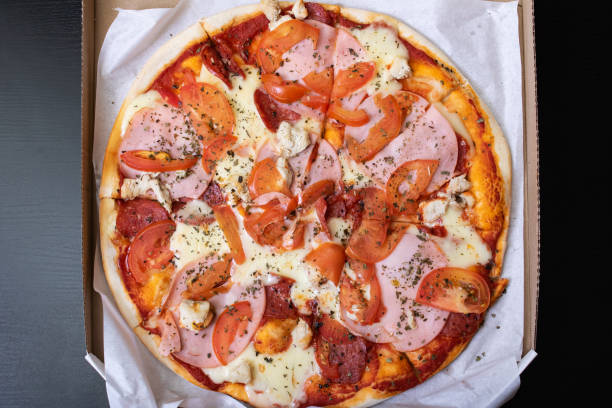 istock Pizza in a box on a wooden table 1306082240