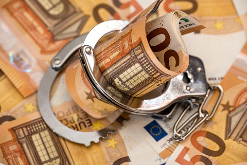 Handcuffs and euro banknotes. corruption and bribery  concept