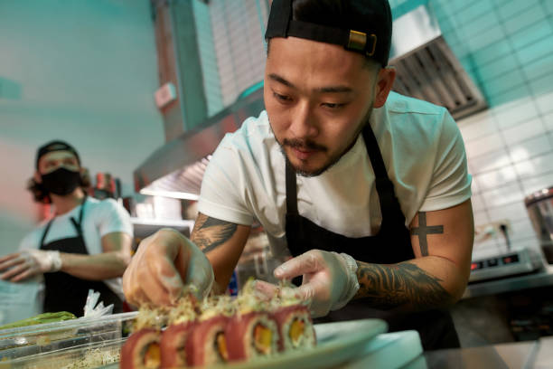 istock Portrait of professional sushi chef carefully adding final touch with dedication to his perfect set of sushi 1306084025