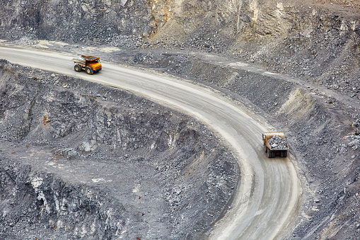 Top view of working BelAZ dump trucks in a stone and crushed stone quarry in Russia, Chelyabinsk region, Miass city.
