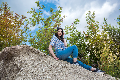 prety woman sit in sand in quarry. enjoy free time in summer vacation