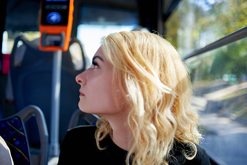 Portrait of a beautiful young woman who rides in a trolleybus.