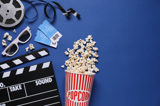 istock Flat lay composition with clapperboard, cinema tickets and 3d glasses on blue background, space for text 1306091436