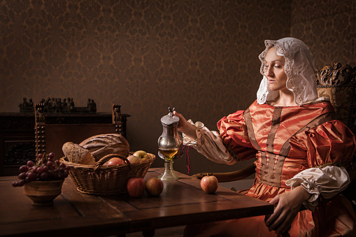 Portrait of a beautiful historical dutch noble woman wearing historically correct outfit in a typical townhouse