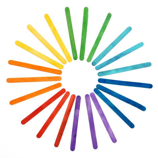 Rainbow color wooden sticks on white. Multicolored abstract round sun.