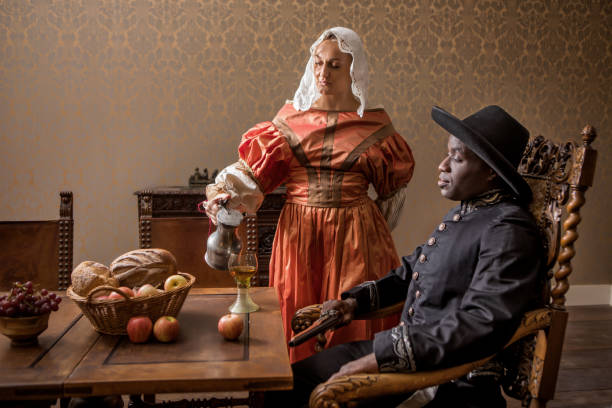 아프리카 전통적으로 옷을 입은 유럽 남자 와 a 서빙 소녀 - luxury women wealth baroque style 뉴스 사진 이미지