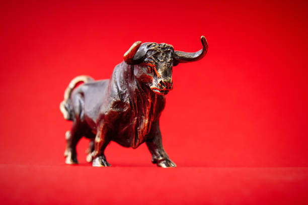 istock Bronze bull figurine on red background 1306092546