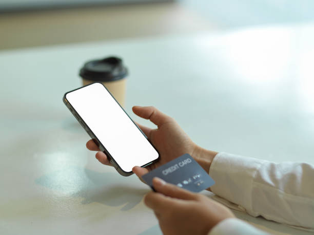 istock Hand using smartphone with mock up screen and holding credit card, online banking concept 1306093056