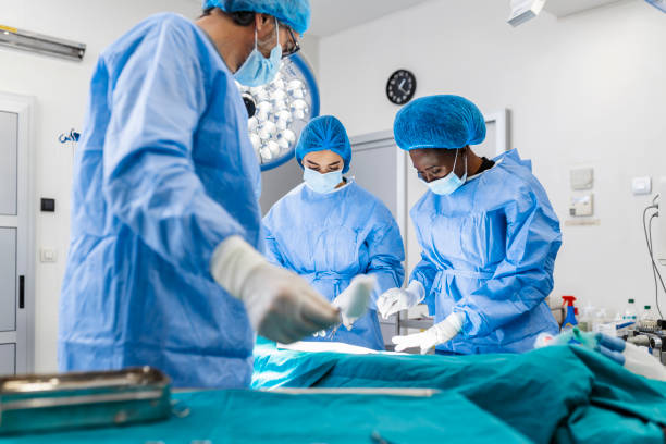 sala operatoria del tavolo chirurgico con strumenti, l'assistente raccoglie gli strumenti per i chirurghi durante il funzionamento. chirurgia in corso. medici professionisti che eseguono la chirurgia. - servizio sanitario nazionale britannico foto e immagini stock