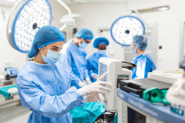 anestesiólogo haciendo un seguimiento de las funciones vitales del cuerpo durante la cirugía cardíaca. cirujano mirando monitor médico durante la cirugía. monitor de control médico para detectar el estado de salud del paciente. - surgery emergency room hospital operating room fotografías e imágenes de stock