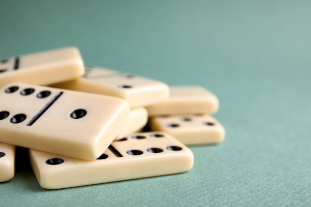 Classic domino tiles on grey background, closeup. Space for text