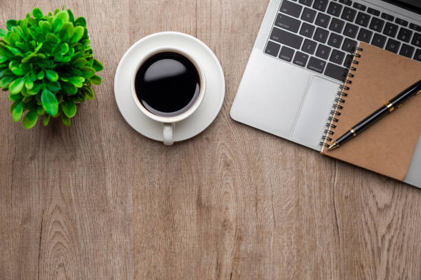 istock Flat lay, top view office table desk. Workspace with, laptop,office supplies, pencil, green leaf, and coffee cup on wood background. 1306097602