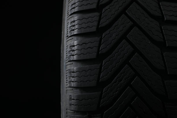 istock Winter tire on black background, closeup. Car maintenance 1306098659