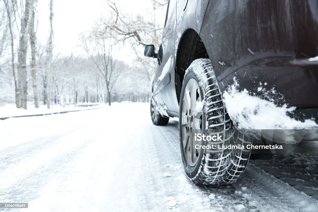 Modern car with winter tires on snowy road Winter Stock Photo