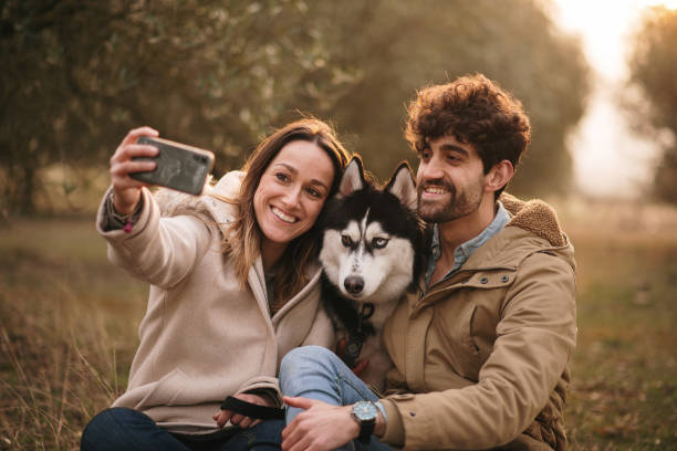 istock Young couple taking a selfie with their Husky dog 1306102550