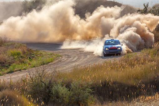 Ukraine, Odesa - July 28, 2019: Sunny summer day. Dusty rally track. Sports car does a lot of dust in turn 06