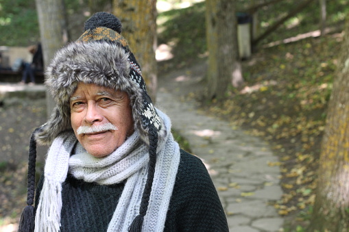 Senior man in the forest with warm clothing.