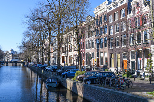 Herengracht in Amsterdam during an early springtime morning in The Netherlands. The streets are empty during the corona COVID-19 pandemic lockdown. Normally the streets in the city center of Amsterdam would be filled with tourists and other people.