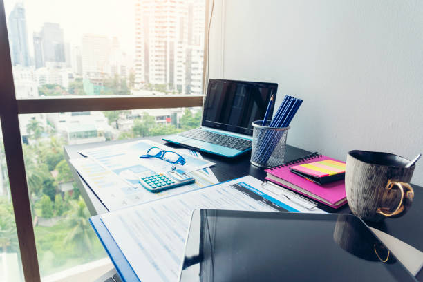 istock Office laptop business financial document chart and graph on wooden table with coffee cup. Flat lay notebook computer laptop on office desk. No people business graph chart mockup on business workspace 1306105178