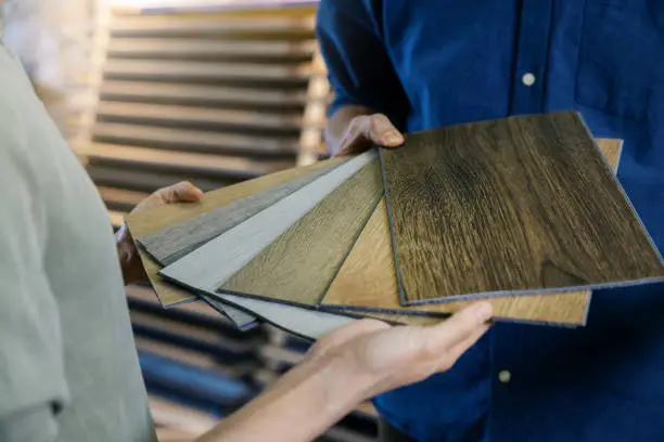 Photo of seller showing wooden texture laminate material samples to customer