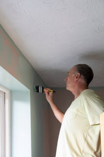 istock Senior man painting an internal wall 1306108916