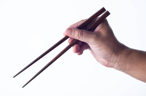 istock hand hold wooden chopsticks on white background 1306109097