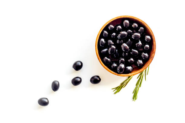 istock Black olives in wooden bowl. Overhead view 1306111506