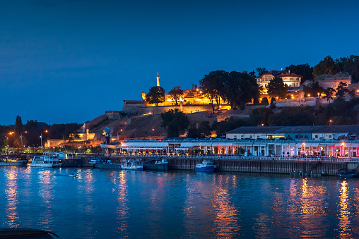Evening view view of Kalemegdan fort and old town of Belgrade, the capital city of Serbia by the Sava river at blue hour. Landmark city view and Europe travel abstract