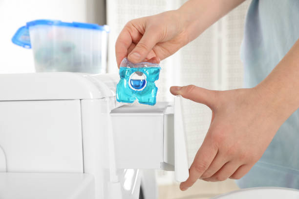 istock Woman putting laundry detergent capsule into washing machine, closeup 1306112561