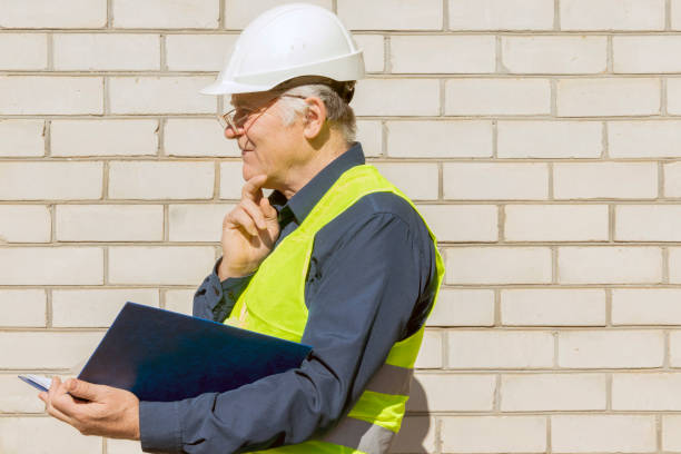 istock Builder with a plan in hand. An engineer in a white helmet looks away and thinks. Construction and architecture concept. 1306113972