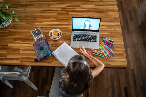 istock High angle view of a girl watching virtual class at home 1306116994