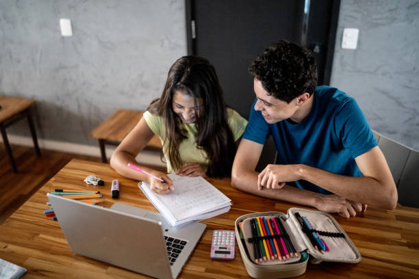 istock Young man helping sister with homework 1306117118
