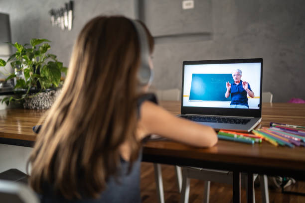 istock Girl watching virtual class on laptop at home 1306117163