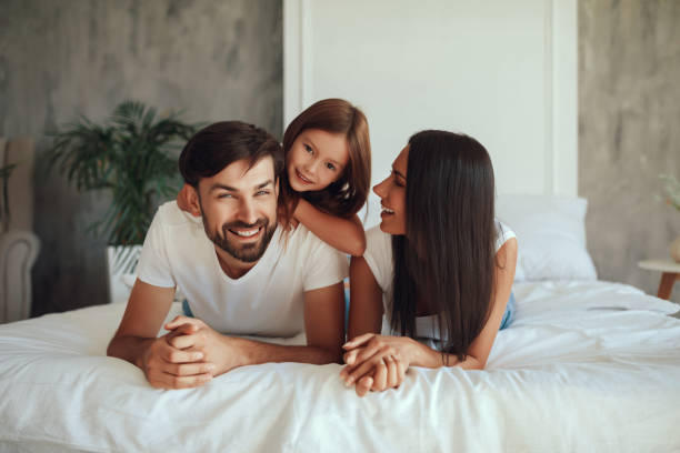 istock Happy father resting on bed with his kid and wife 1306118612