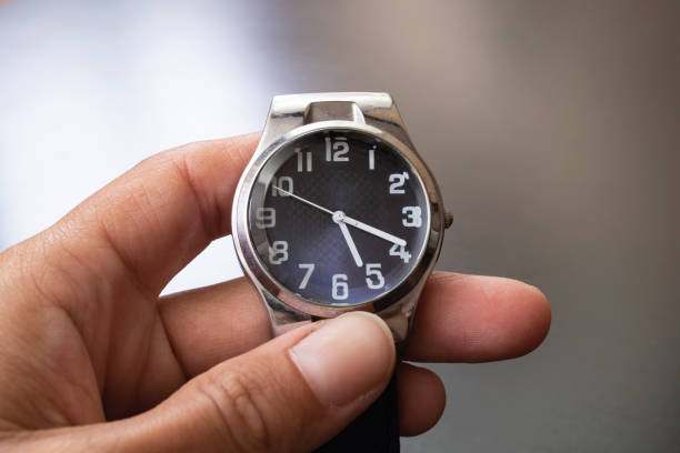 istock Blue wristwatch in hand on gray background 1306120320