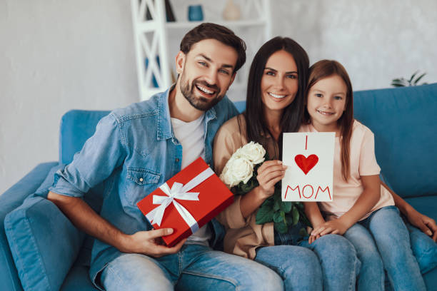 istock Happy young mom getting gifs from kid and man 1306122468