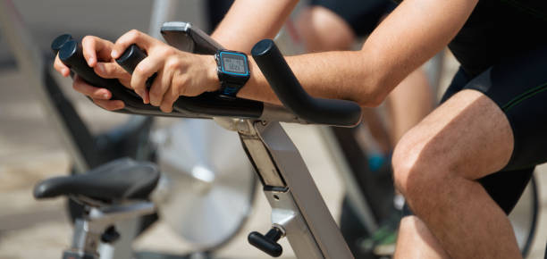 People working out on exercise stationary bicycle Active people working out on exercise stationary bicycle spin bike stock pictures, royalty-free photos & images