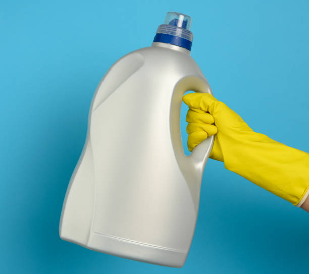 istock hand holds a big bottle with liquid detergent for washing clothes on a blue background 1306123085