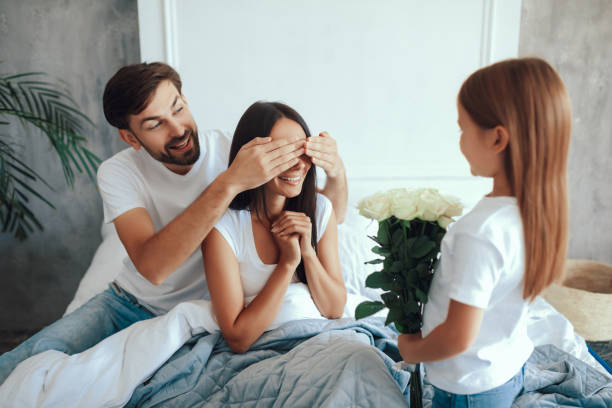istock Cute little girl and her dad congratulating mother 1306123708