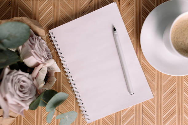 istock Wooden coffee table with flowers flat lay, coffee cup, flowers, note pad, pen 1306124447