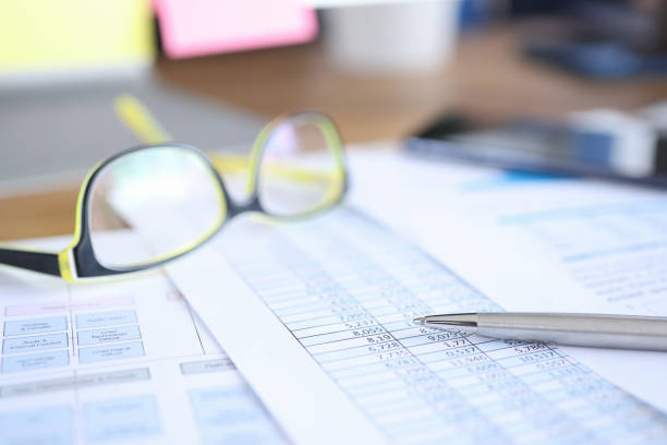 Glasses for vision lying on documents with numbers closeup