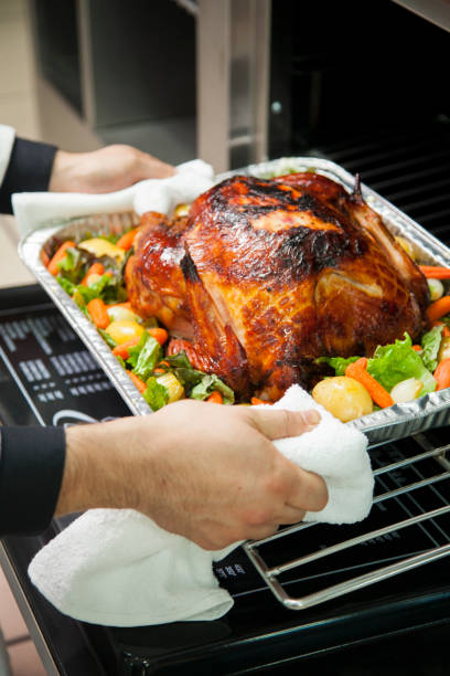 istock Hands of cook preparing roasted chicken with salad 1306127176