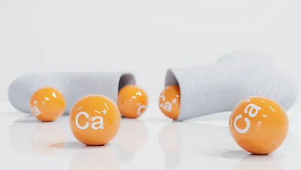 Photo of Calcium with Bone-building supplements concept. Yellow ball CA text and a half bone on the white background. Health care vitamin supplement. 3d render.