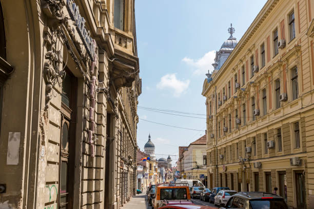 Old buildings, Orthodox church, European Union flag and pigeons on town square in Timisoara