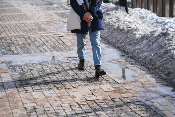 istock Walking on wet sidewalk with melting dirty snow 1306127937