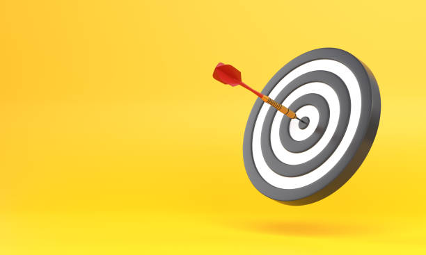 istock Dart hitting a target on the center on yellow background with copy space 1306130757