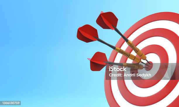 Three Darts Hitting A Red Target On The Center On Blue Background With Copy Space Stock Photo - Download Image Now