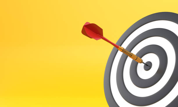 istock Dart hitting a target on the center on yellow background with copy space 1306130788